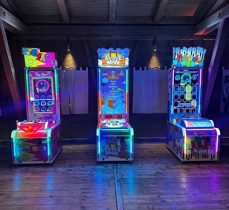 3 moderne spielautomaten in einer almhütten location.