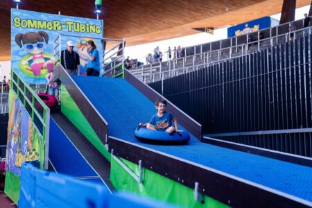 rasante abfahrt auf einem gummiring auf blauer kunstpiste.