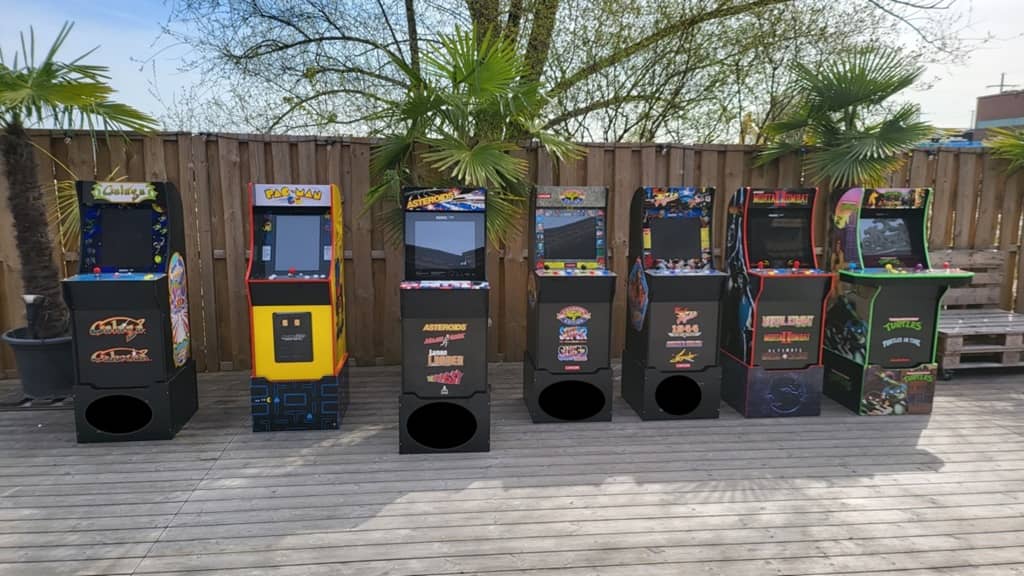 7 arcade automaten aufgereiht auf einer terasse