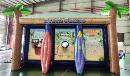 aufblasbare struktur im thema hawaii und beach. 2 aufblasbare palmen rechts und links in der mitte diverse spiele und 2 surfbretter aufblasbar in rot und blau.