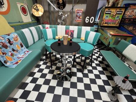 American Diner mit Sitzen, Jukebox, Dekos und einem schwarz weiss gekacheltem Boden.