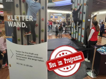 Personen beim Klettern an einer modernen Endlos-Kletterwand in einem Einkaufszentrum mit Aufschrift Neu im Programm.