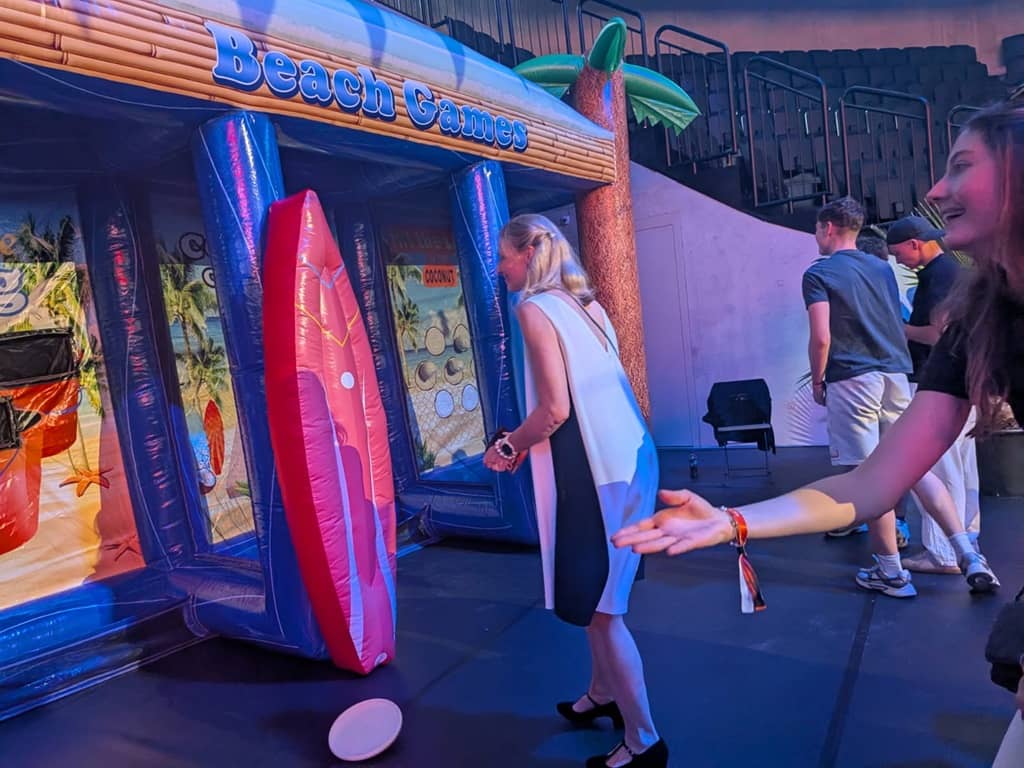 2 damen spielen an der aufblasbaren hawai spielestation mit klettbällen.