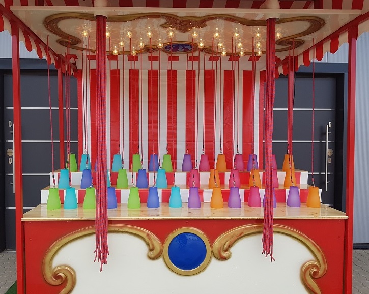 schöner nostalgischer stand mit beleuchtung. es hängen viele fäden runter an denen dann die eimer mit preisen sind.