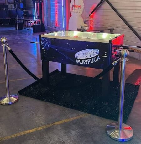 hockey spiel in einem kasten wie ein tischfussball. steht auf einem schwarzen teppich.