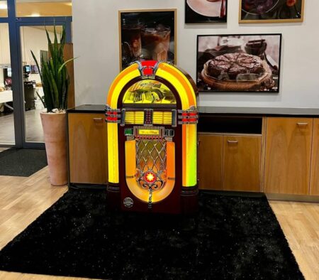 wurlitzer jukebox beleuchtet auf schwarzem teppich