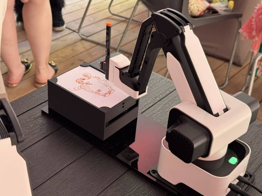 ki sketchbot roboter zeichnet bild vom gast.