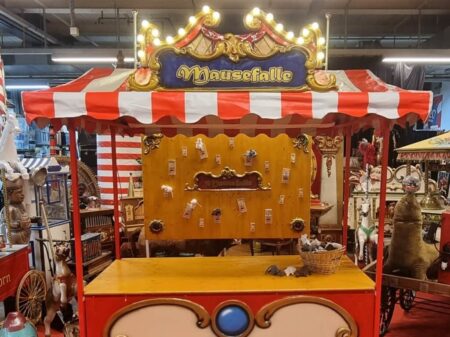 Nostalgisches Mausefalle Wurfspiel mit roten und weißen Markisen und gespannter Wurfwand im Hintergrund