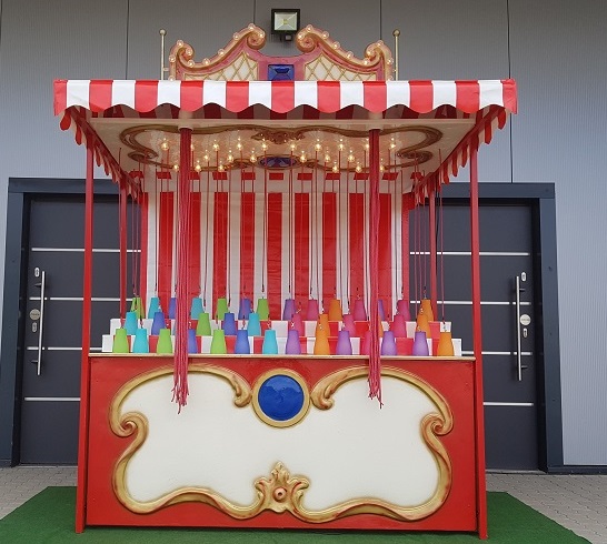 schöner nostalgischer stand mit beleuchtung. es hängen viele fäden runter an denen dann die eimer mit preisen sind.
