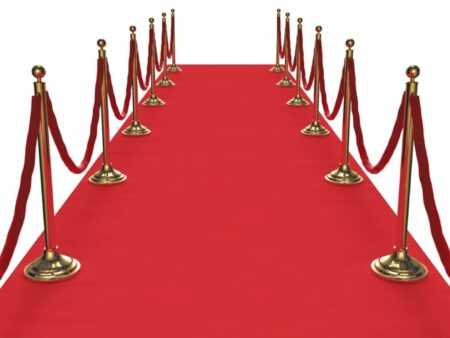 Roter Teppich mit goldenen Absperrpfosten und roten Samtseilen in einer Veranstaltungsszenerie