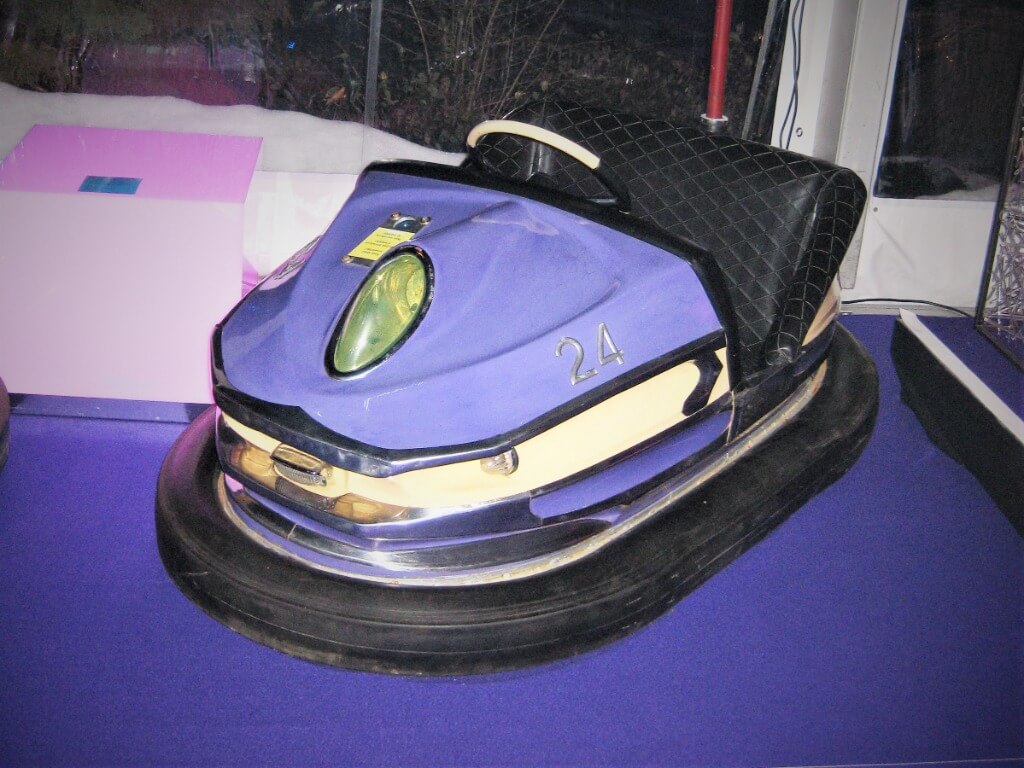 Blau-weißer Autoscooter mit der Nummer 24 als dekoratives Element auf violettem Boden