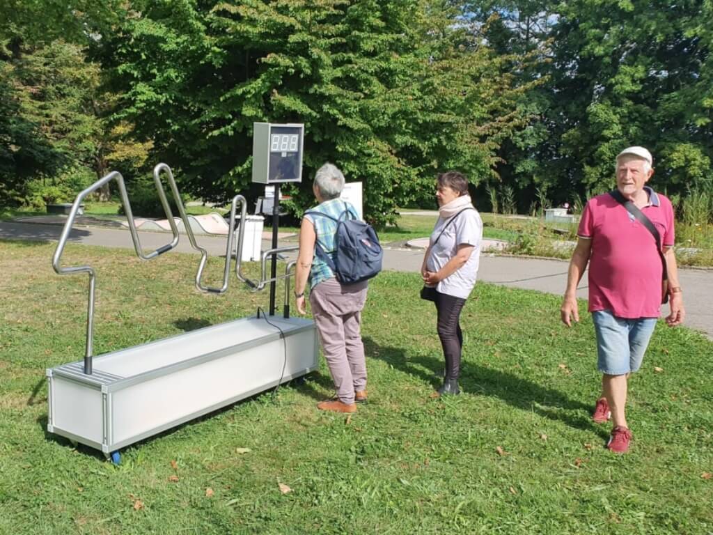 Person spielt den XXL Heissen Draht mit großer digitaler Zeitanzeige im Freien.