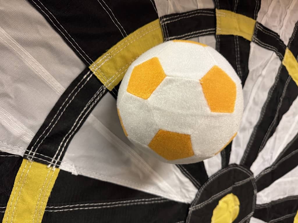 mini ausschnitt einer aufblasbaren fussball dart wand. ein klettball klebt an der scheibe.